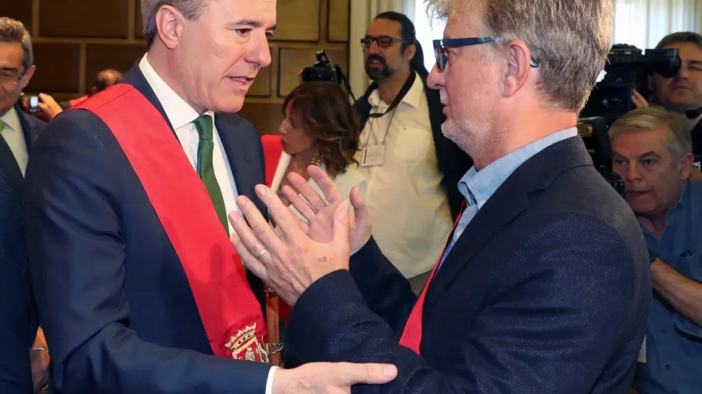 Pedro Santisteve conversa con el nuevo alcalde, Jorge Azcón, tras el pleno de constitución del Ayuntamiento de Zaragoza.
