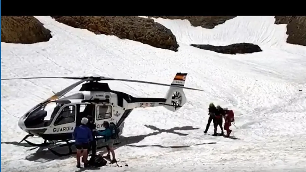 Los especialistas de Panticosa ayudan al montañero francés a llegar al helicóptero.