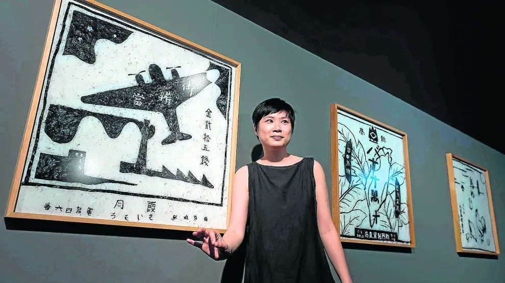 La artista Hoy I-Ting posa delante de varias piezas de la exposición ‘Tejiendo identidades’.