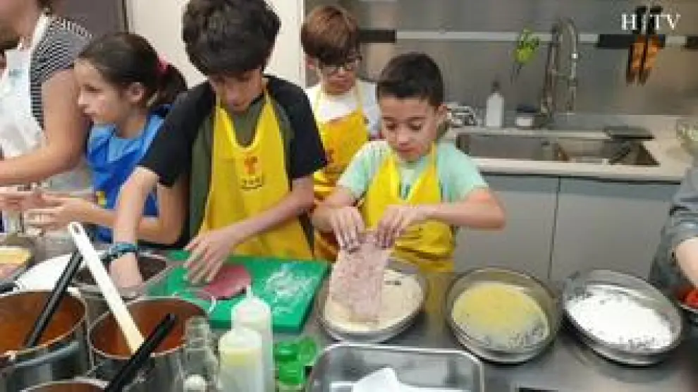 La minichef zaragozana María Lasala nos explica, paso a paso, cómo preparar y cocinar un escalope a la milanesa. Una de las recetas que los más pequeños aprenden a hacer en los cursos de La Zarola, en Zaragoza.