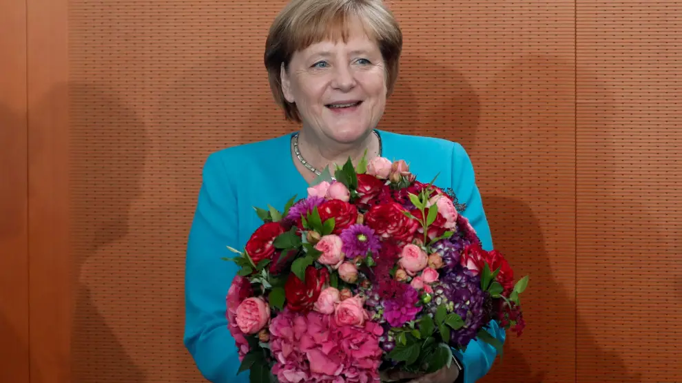Chancellor Angela Merkel reacts after receiving a bouquet of flowers for her 65th birthday at the cabinet meeting in Berlin, Germany, July 17, 2019. REUTERS/Fabrizio Bensch [[[REUTERS VOCENTO]]] GERMANY-POLITICS/
