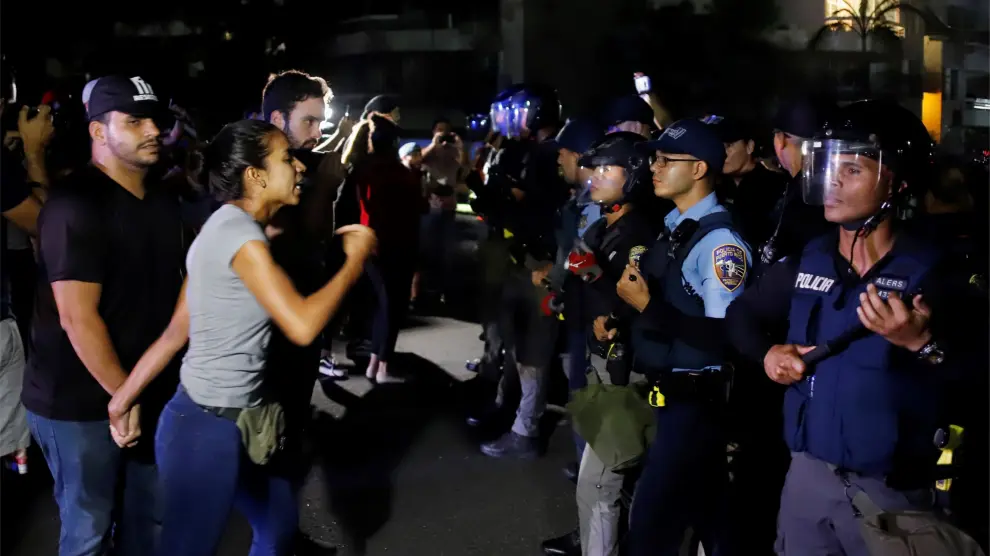 Manifestantes se enfrentan a la policía mientras el gobernador Ricardo Roselló mantiene una reunión con alcaldes federados.