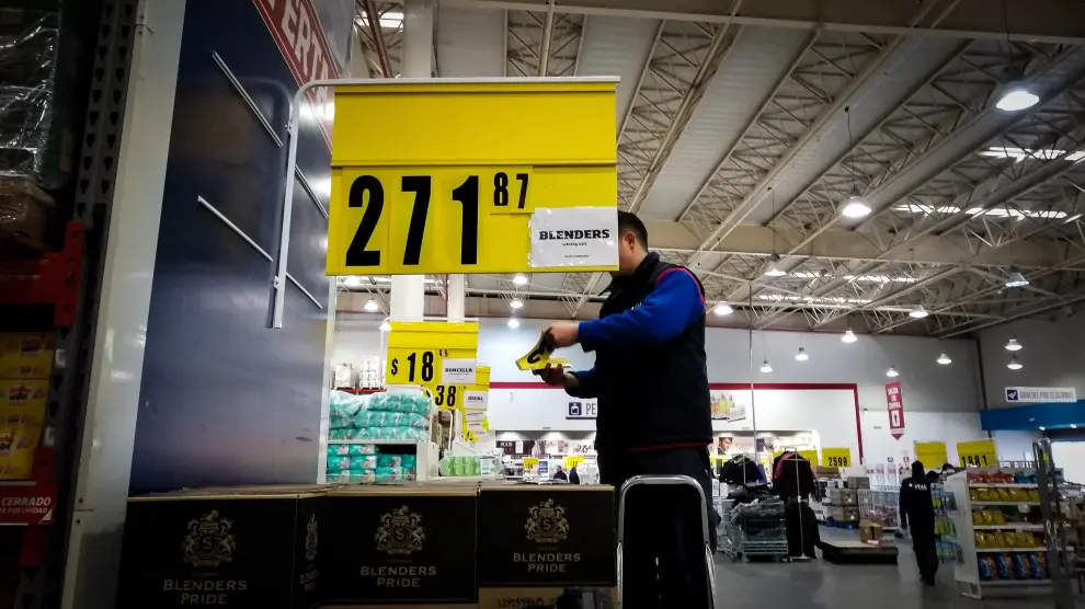 Un empleado cambia los precios ante la incierta situación económica argentina.