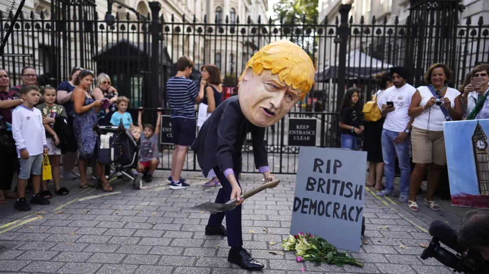 Un ciudadano con una careta de Boris Johnson escenifica la muerte de la democracia británica