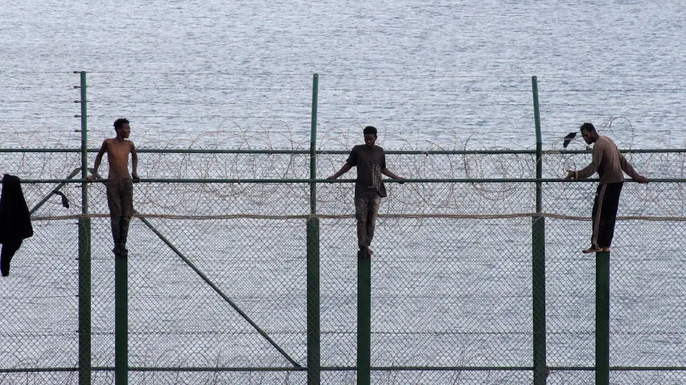 African migrants stand on a border fence as they attempt to cross into Spanish territories, between Morocco and Spain's north African enclave of Ceuta, Spain, August 30, 2019. REUTERS/Stringer NO RESALES. NO ARCHIVES [[[REUTERS VOCENTO]]] EUROPE-MIGRANTS/SPAIN-CEUTA