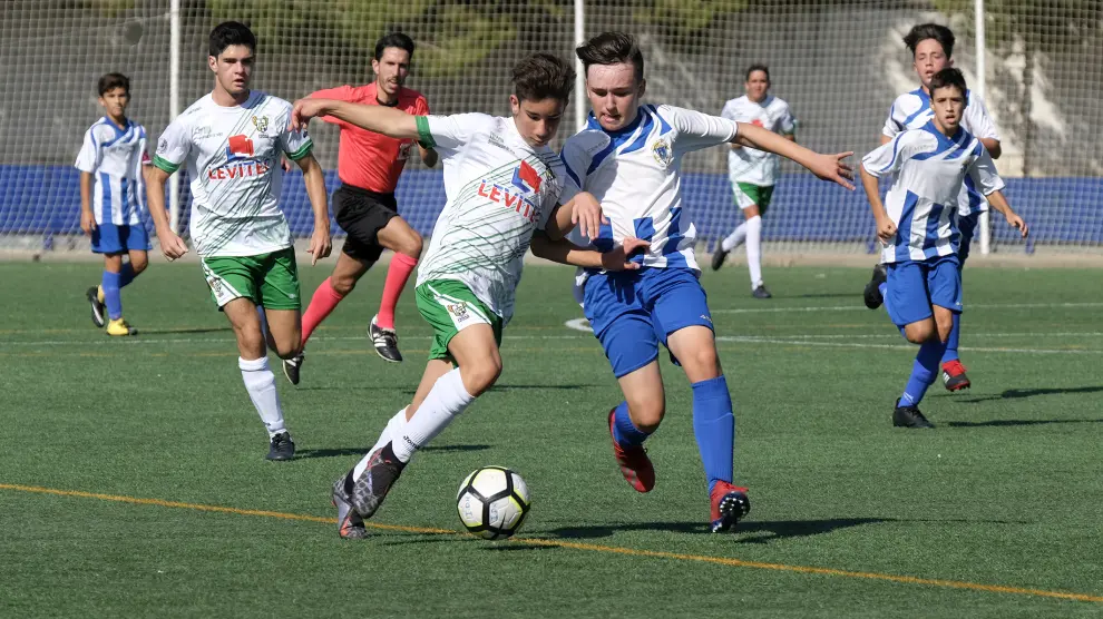 Un jugador del Peñas Oscenses conduce ante la presión de un rival ejeano.