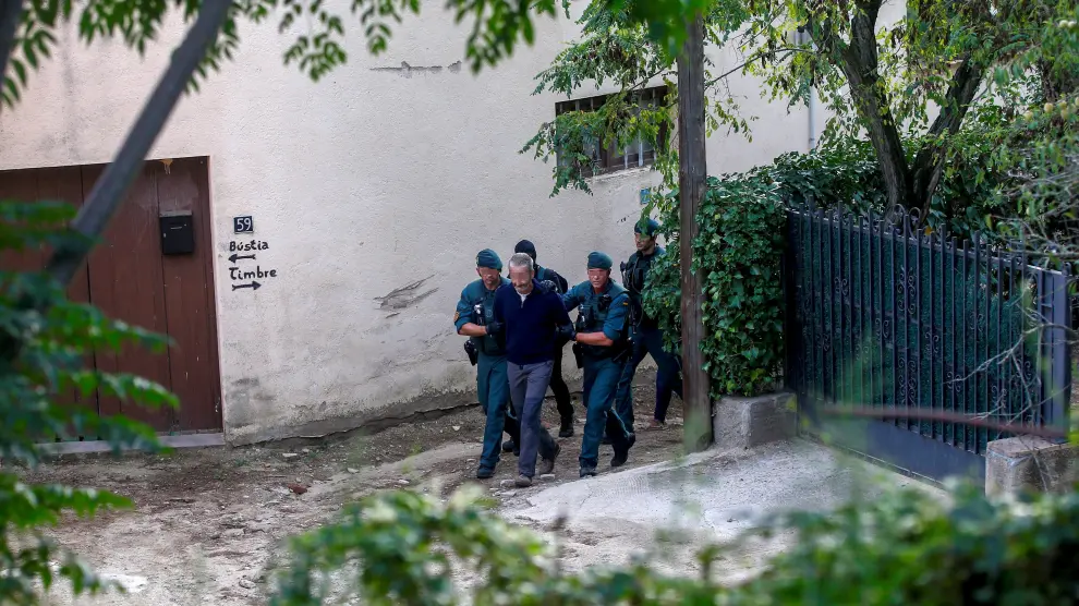 Agentes de la Guardia Civil trasladan a una de las nueve personas detenidas en Cataluña, que tenían en su poder material para fabricar explosivos caseros