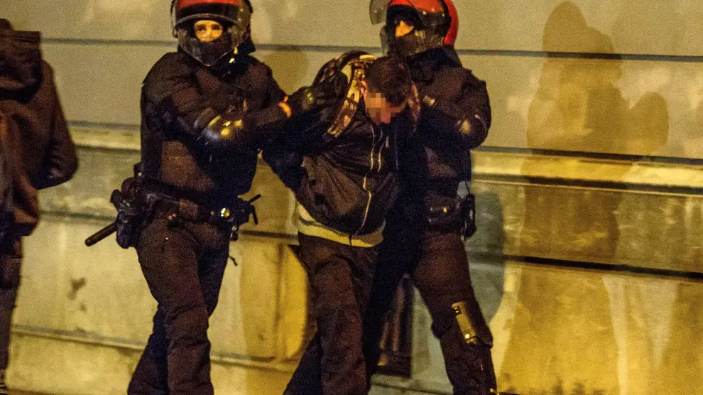 Agentes de la Ertzaintza detienen a un hombre por los altercados surgidos a raíz de un acto de Vox en Bilbao.