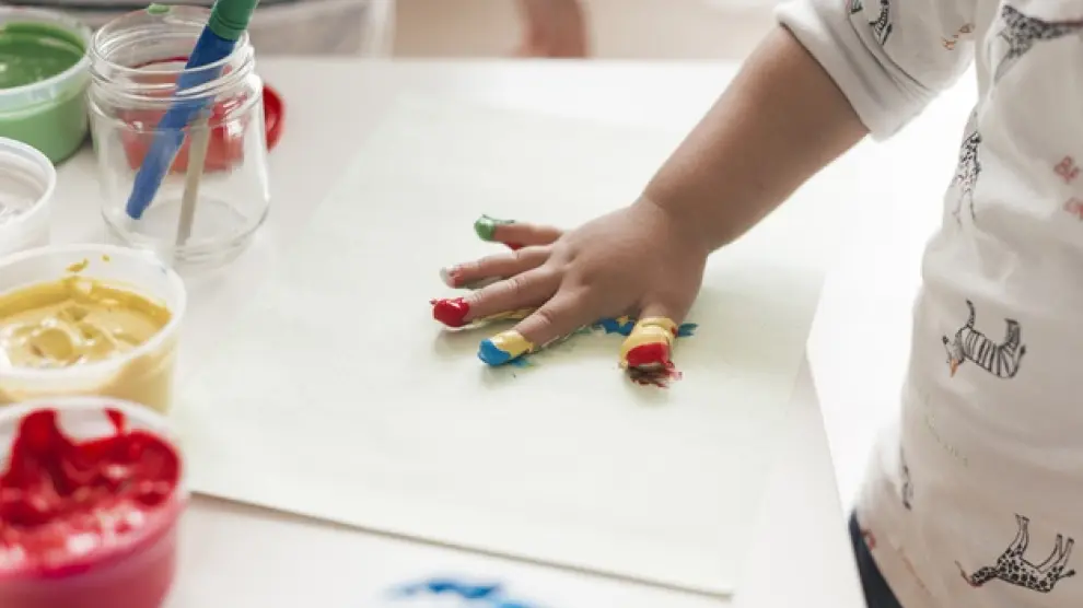 Un niño pinta con las manos.