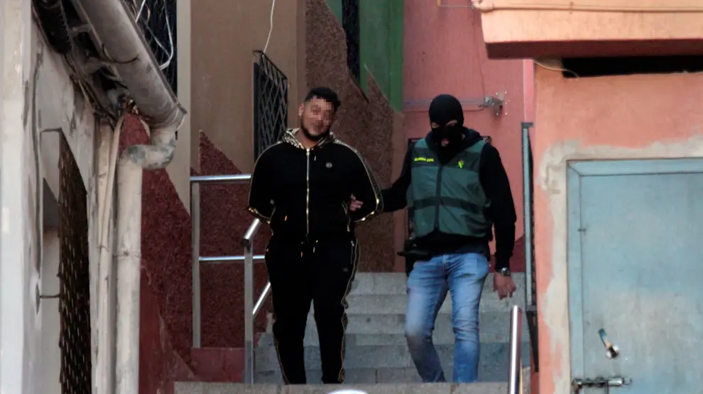 Un miembro de la Guardia Civil con uno de los detenidos durante la operación contra el tráfico de drogas y de inmigrantes que se ha iniciado en Ceuta y que se extiende a otras localidades, como Algeciras y Málaga.