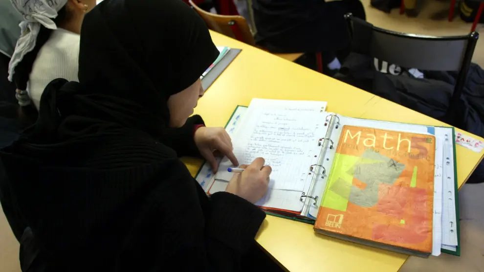 Schoolgirls with Islamic headscarves study in the private catholic school of Saint Mauront in Marseille January 14, 2004. French government planned to submit to parliament a draft law banning religious symbols such as Islamic headscarves in state schools, despite protest from Muslims in France and around the world. REUTERS/Jean-Paul Pelissier FRANCE