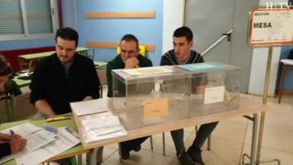 Adrián Villanueva, de 22 años, está al frente de una de las mesas del colegio Hermanos Marx del Actur, en Zaragoza. El primer voto ha entrado en su urna a las 9.00 en punto, pero su trabajo ha empezado mucho antes.