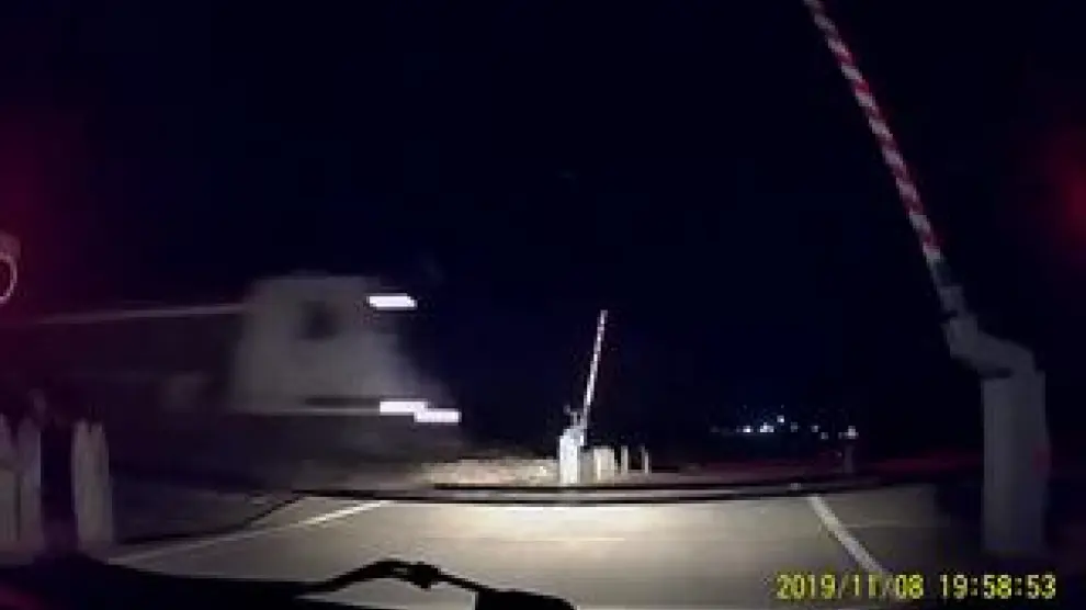 Un conductor frena ante la barrera levantada segundos antes de que pase el tren.