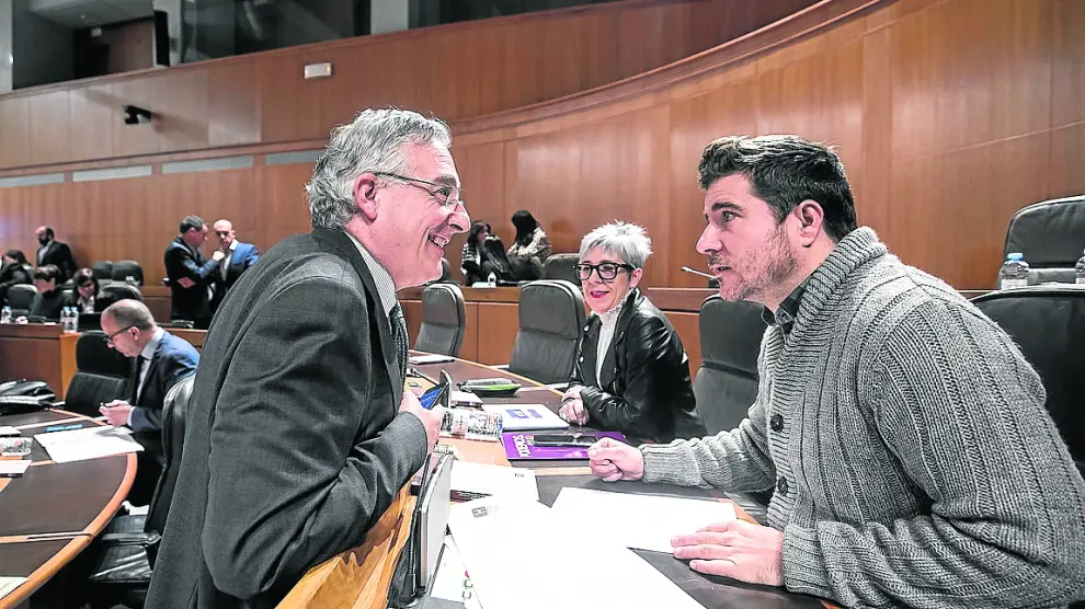 El consejero de Agricultura, Joaquín Olona, y Nacho Escartín (Podemos), este jueves en el pleno.