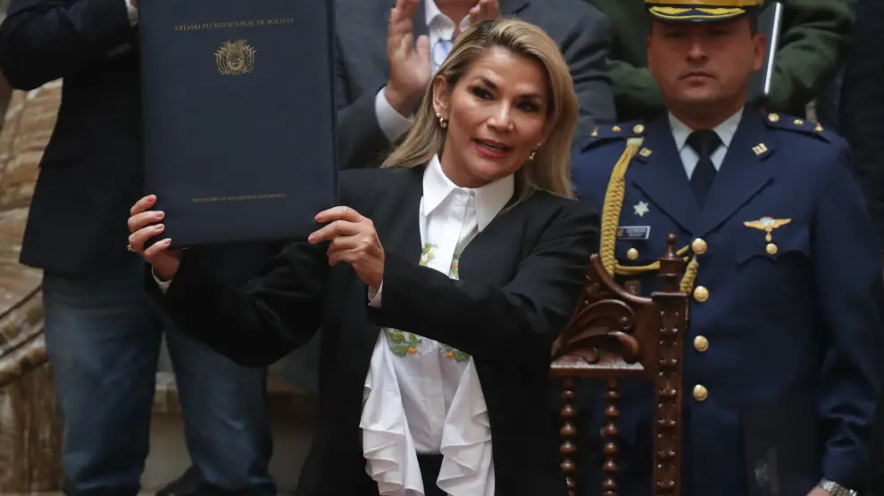 La presidenta interina de Bolivia, Jeanine Áñez, sostiene un documento durante la promulgación de una ley de urgencia este domingo en La Paz