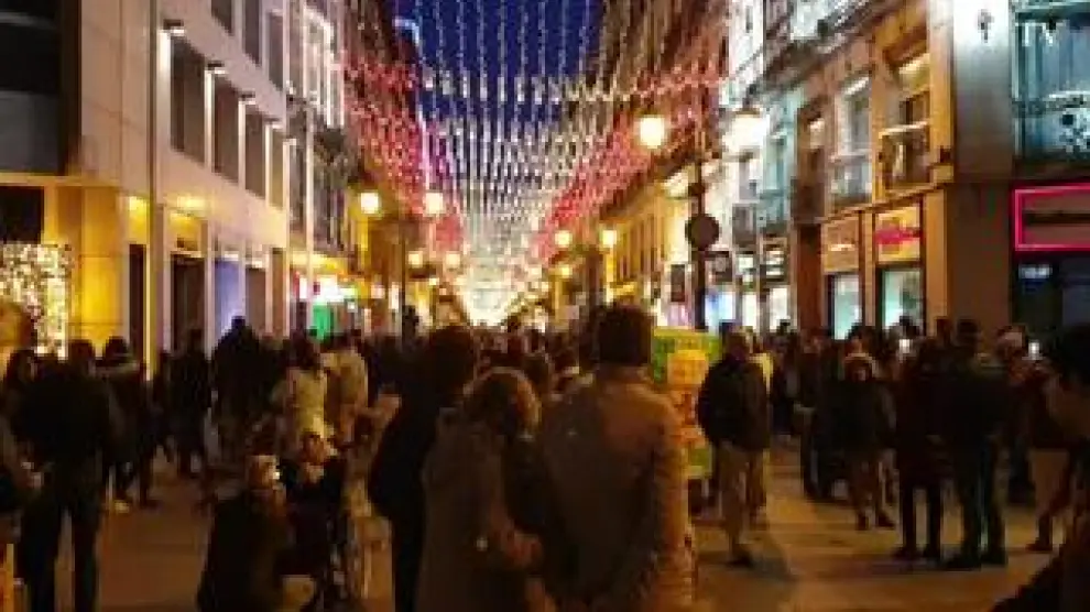 La iluminación navideña de la calle de Alfonso I de Zaragoza se ha tornado, este viernes, de blanca a rojigualda para celebrar el Día de la Constitución española. Decenas de ciudadanos se agolpaban en ambos extremos de la calle para fotografiar la gran bandera de luces.