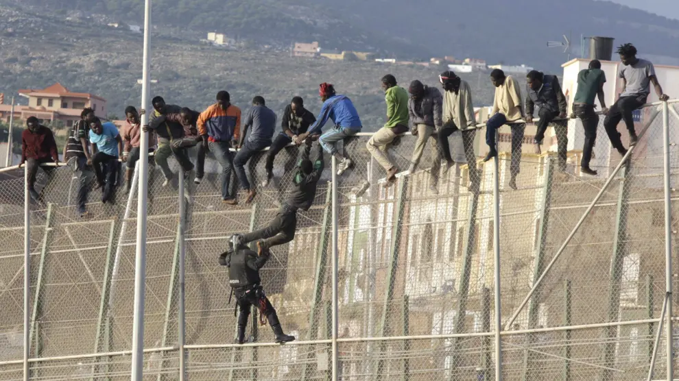 Un centenar de inmigrantes permanecen encaramados en la valla fronteriza entre Melilla y Marruecos en una imagen de archivo.