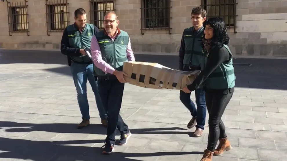 Agentes de la Guardia Civil trasladan la última talla románica recuperada al Museo de Huesca para su estudio.