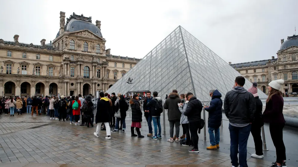 Turistas hacen fila en los alrededores del Museo de Louvr, en París.