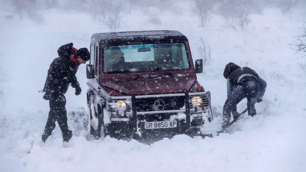 Dos hombres intentan sacar su todoterrreno atrapado en la nieve en las proximidades de Yecla (Murcia)