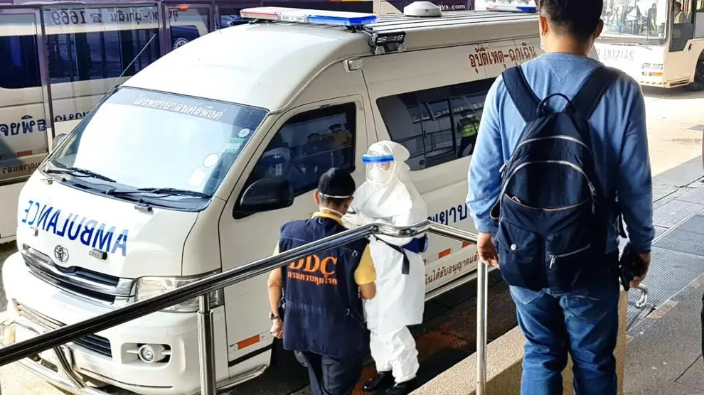 Foto publicada por la Oficina de Salud Pública de Chiang Mai (Tailandia) muestra que el personal médico transfiere a un paciente chino que tiene fiebre en una ambulancia desde el aeropuerto hasta un hospital.