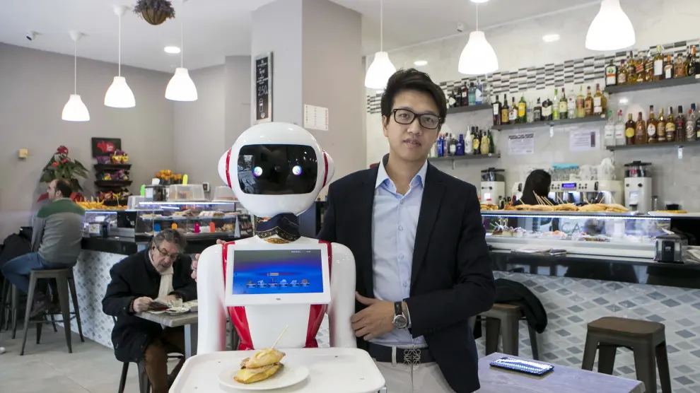 Cristian Yang, responsable de la cafetería-restaurante Atrapasueños, con la primera robot-camarera de Zaragoza.