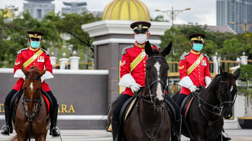 Los guardias reales de Malasia usan máscaras protectoras mientras hacen guardia afuera del Palacio Nacional, en Kuala Lumpur