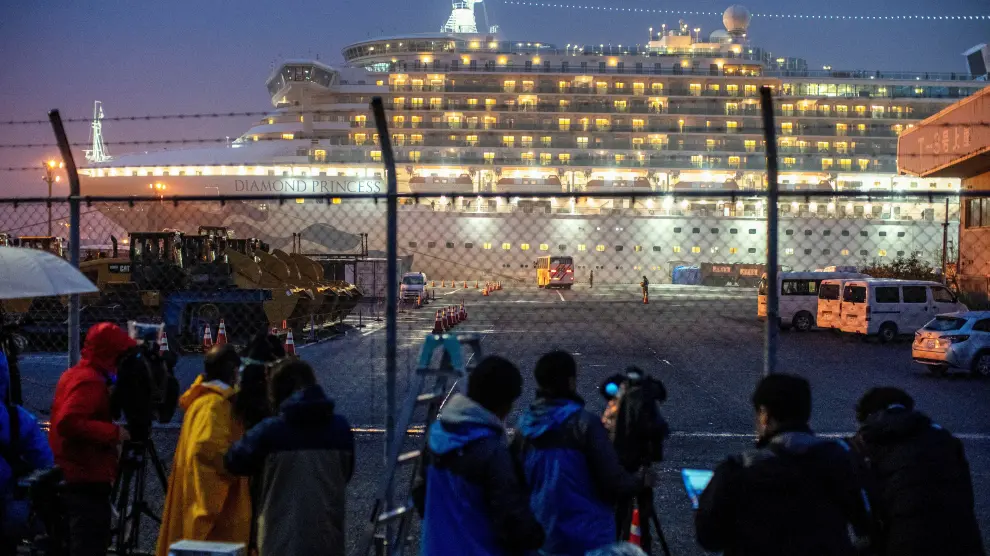 Un bus llega a la zona del crucero Diamond Princess, donde esperan docenas de pasajeros para someterse al test del coronavirus.
