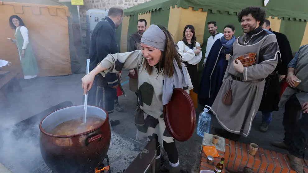 Una joven da vueltas al puchero en una de las jaimas en la fiesta medieval de Teruel.