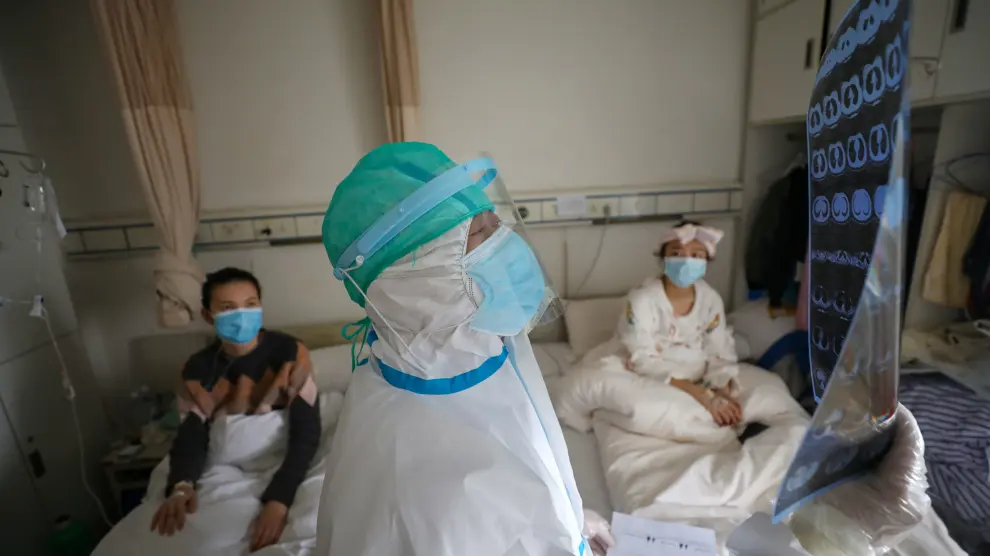 Medical worker in protective suit inspects a CT scan image at a ward of Wuhan Red Cross Hospital in Wuhan