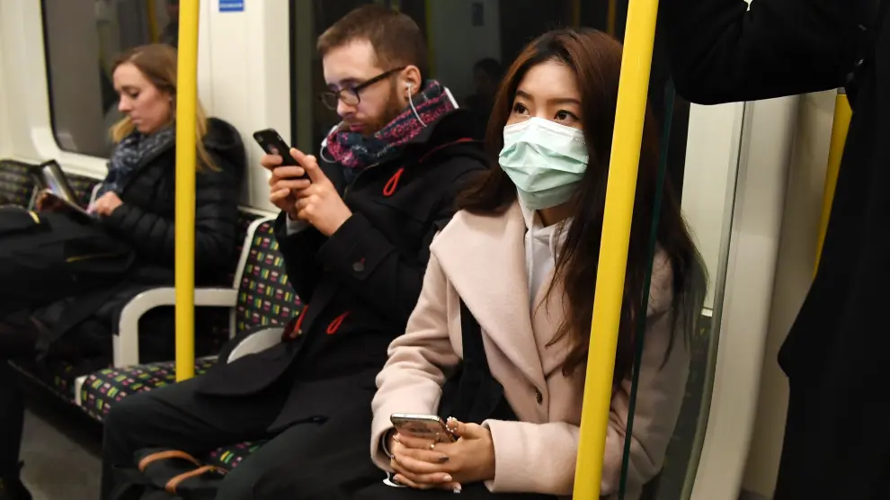 Una mujer con máscara en el metro de Lon