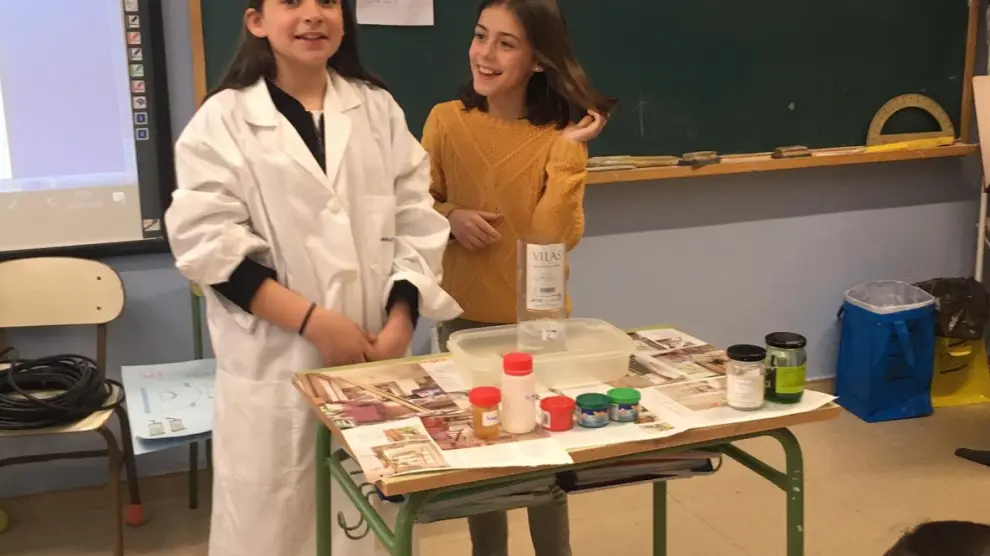 Dos alumnas, a punto de realizar un experimento ante el resto de sus compañeros