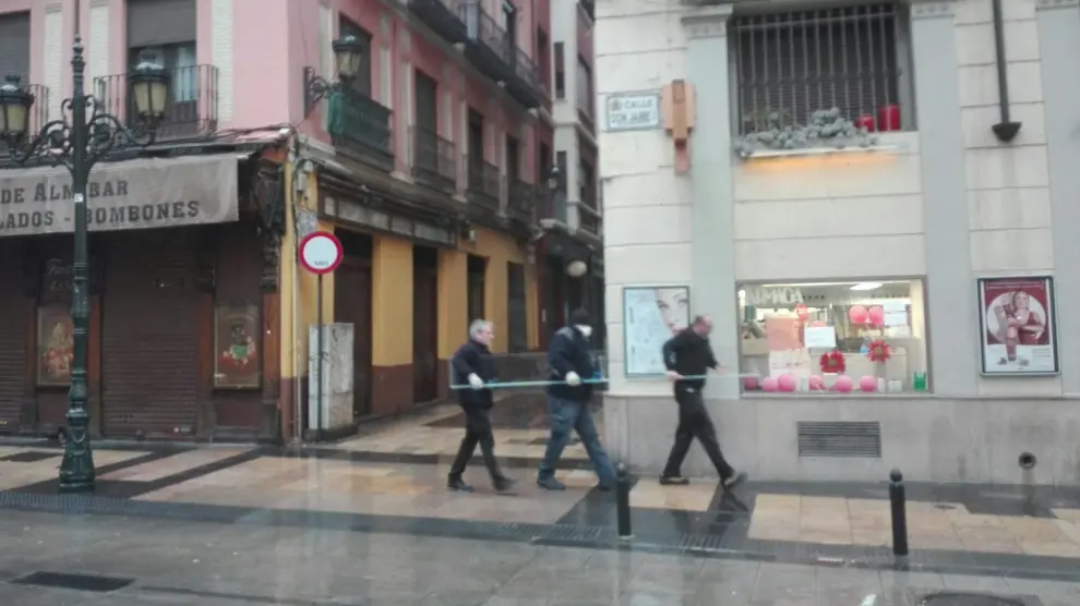 Unos trabajadores trasladan un vidrio por la calle Don Jaime.