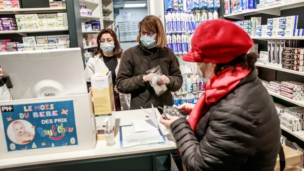 Varias personas con mascarillas este martes en una farmacia de París.