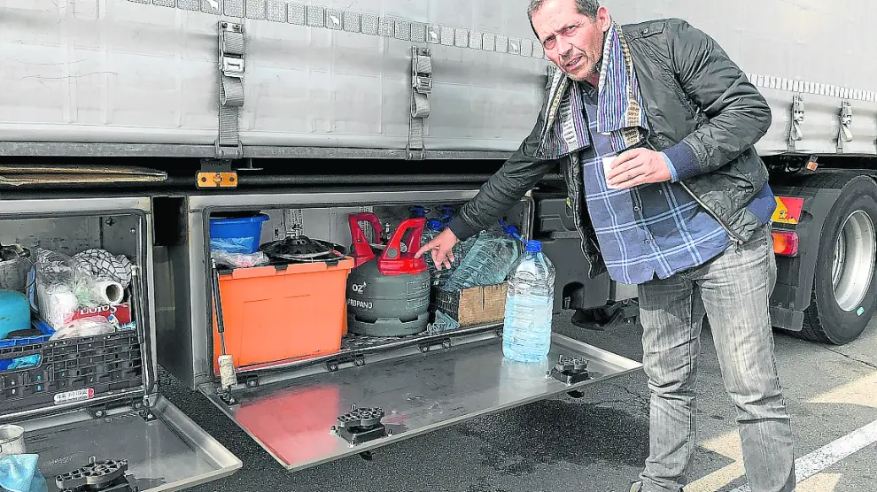 El camionero portugués Víctor Silva muestra su cocina de gas mientras toma un café