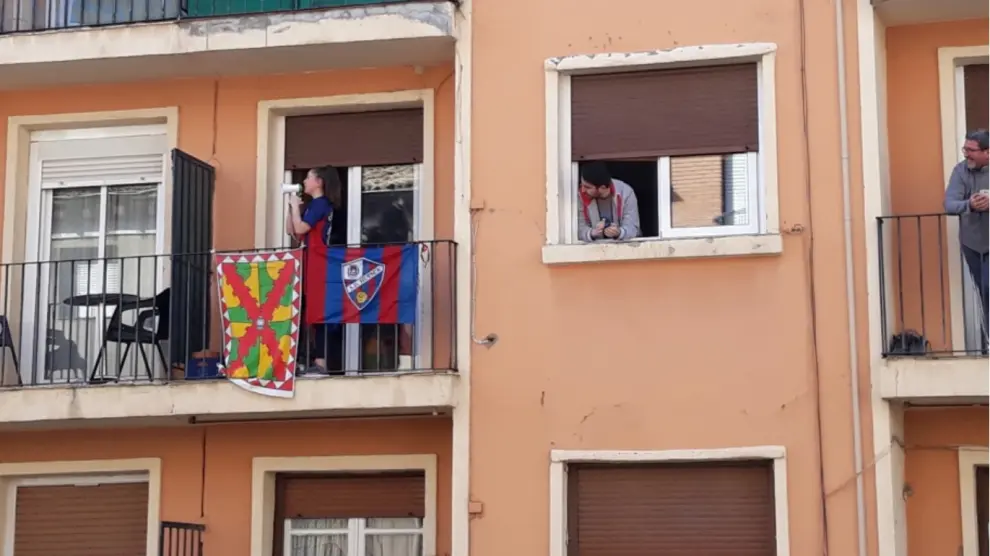 Una seguidora de la SD Huesca canta el himno azulgrana con un megáfono.