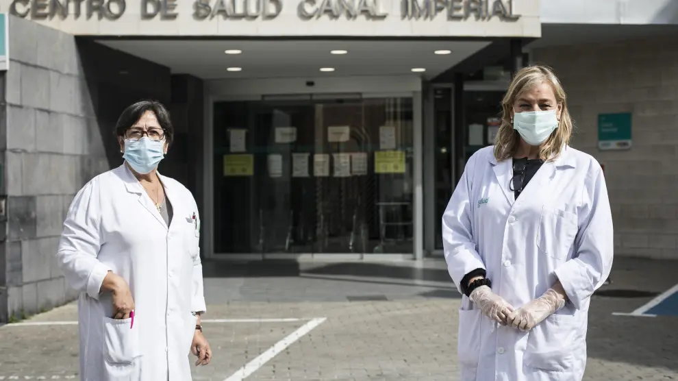 La enfermera Pilar Arilla (a la ziquierda) y la médico Pilar López Esteban, en la entrada del centro de salud Canal Imperial, en el barrio de Venecia, el pasado viernes.