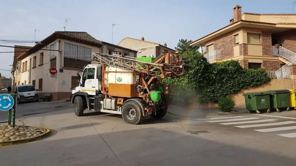 Un agricultor utiliza su maquinaria para desinfectar las calles en un municipio aragonés.