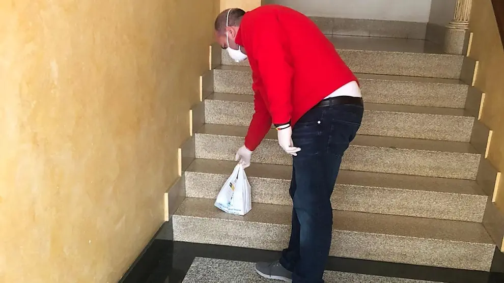 Un voluntario deja una bolsa con medicamentos en una casa del Bajo CInca