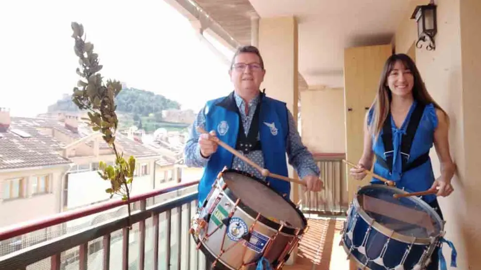 Dos alcañizanos tocan el tambor desde el balcón de su casa durante el confinamiento