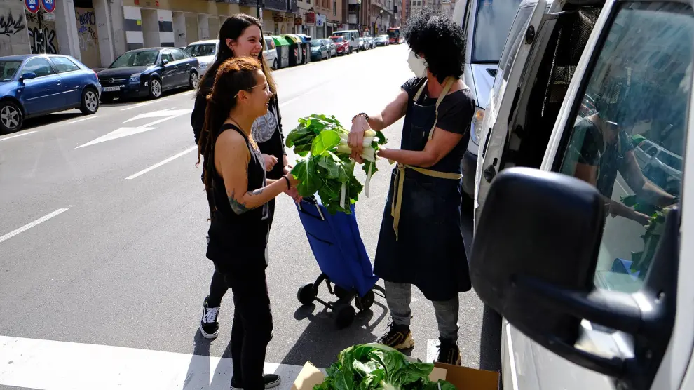 Nieves, Nato, y Lucía, vecinas del barrio de la Madalena que se han organizado para repartir verdura fresca.