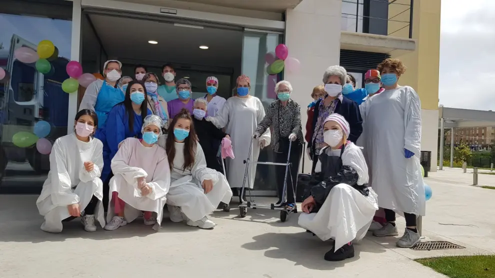 Las residentes restablecidas del coronavirus posan con los trabajadores a las puertas de la residencia de Los Paúles de Teruel.