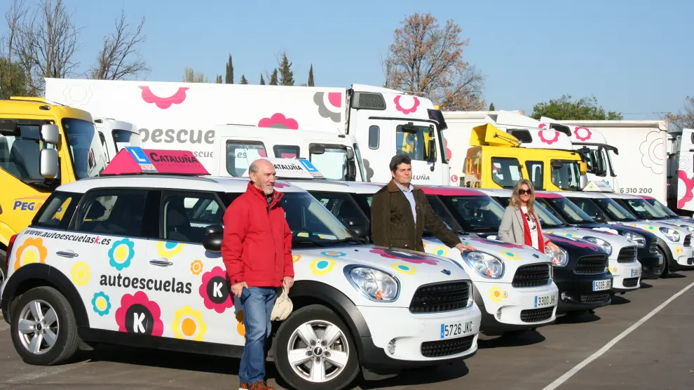 En la imagen, parte de la flota de vehículos y miembros del equipo de Autoescuelas K.
