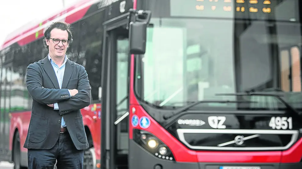 El director de Avanza Zaragoza, Guillermo Ríos, junto a un autobús urbano.