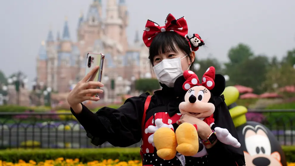 Una visitante vestida de Minnie Mouse se hace un selfi en el parque Disney de Shanghái.