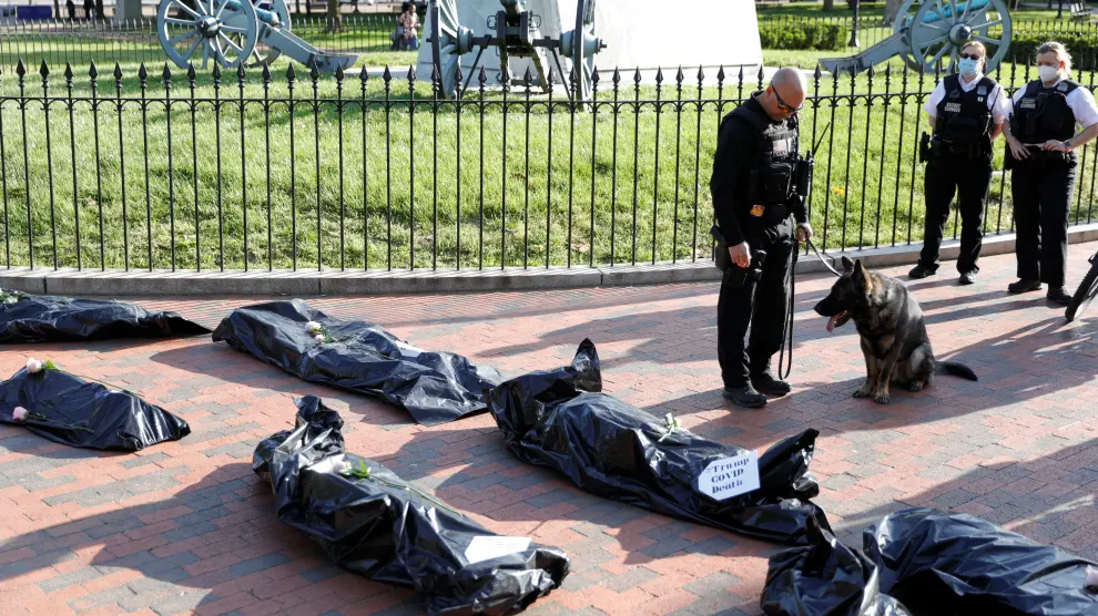 Protestors hold a funeral procession demonstration for the coronavirus disease (COVID-19) victims outside of the White House in Washington
