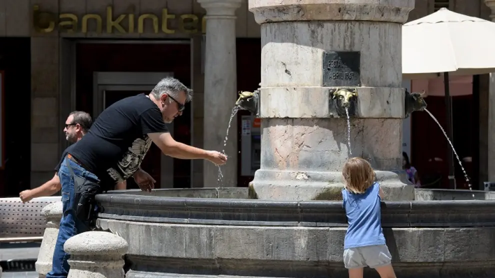 Gente refrescándose en la fuente del Torico de Teruel