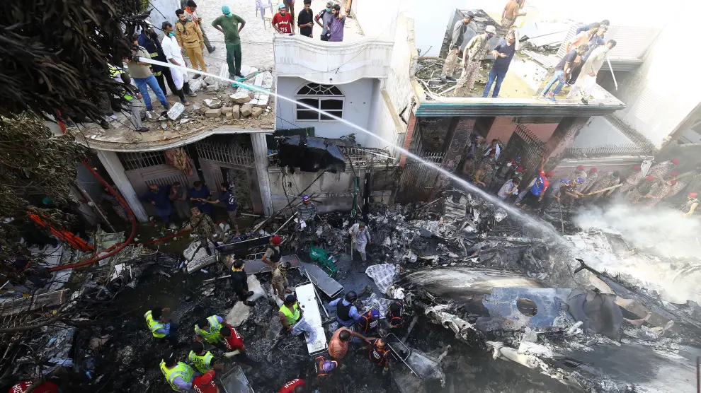 Decenas de trabajadores de servicios de emergencias y voluntarios buscan a las víctimas del accidente aéreo en Karachi (Pakistán)