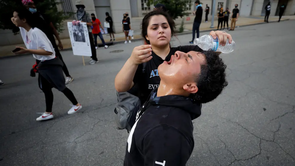 A protester pours water in the eyes of a friend affected by tear gas during nationwide unrest following the death in Minneapolis police custody of George Floyd, in Raleigh, North Carolina, U.S. May 30, 2020. Picture taken May 30, 2020. REUTERS/Jonathan Drake [[[REUTERS VOCENTO]]] MINNEAPOLIS-POLICE/PROTESTS-RALEIGH