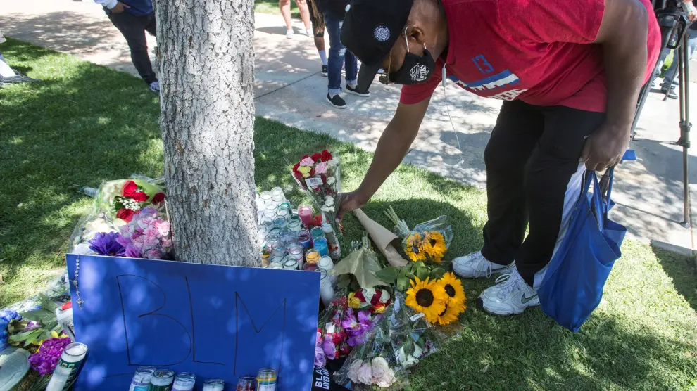 Un manifestante deposita flores en memoria del joven que apareció colgado de un árbol en la ciudad de Palmdale, a las afueras de Los Ángeles.